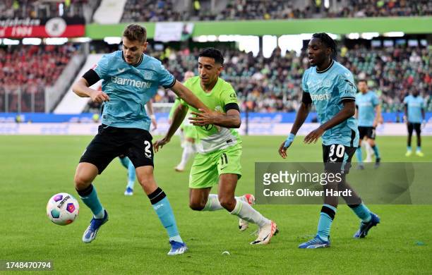 Josip Stanisic of Bayer Leverkusen controls the ball whilst under pressure from Tiago Tomas of VfL Wolfsburg during the Bundesliga match between VfL...