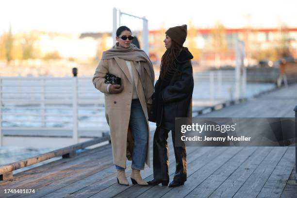 Benthe Liem seen wearing gold earrings, black sunglasses, beige wool knit scarf, white cream wool knit pullover, beige long coat, brown suede leather...