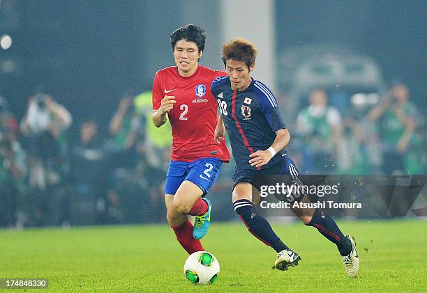 Yoichiro Kakitani of Japan and Kim Changsoo of South Korea compete for the ball during the EAFF East Asian Cup match between Korea Republic and Japan...