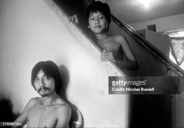 Portrait of a father and his son inside of their apartment in Allen parkway Village in 1983 in Houston, Texas.