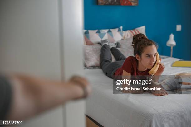 girl lying on her bed while talking to her friends on her vintage phone. - telefone fixo imagens e fotografias de stock