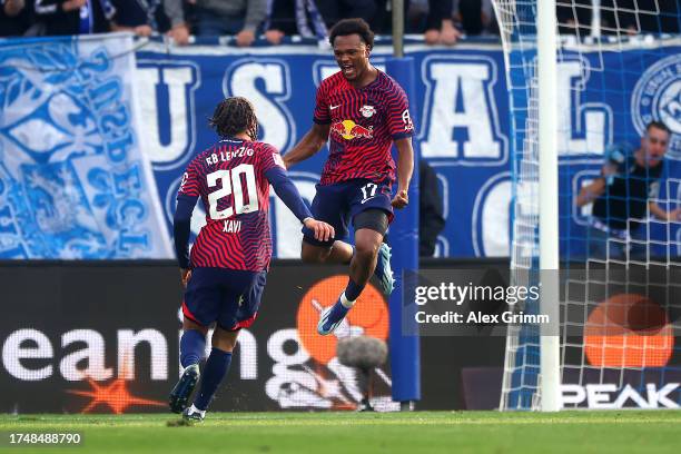Lois Openda of RB Leipzig celebrates with teammate Xavi Simons after scoring the team's third goal during the Bundesliga match between SV Darmstadt...