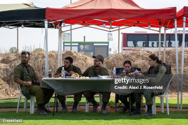 Soldiers eat lunch at spot where volunteers are handing out food on October 21, 2023 near Ofakim, Israel. Today marks two weeks since the kibbutzim...