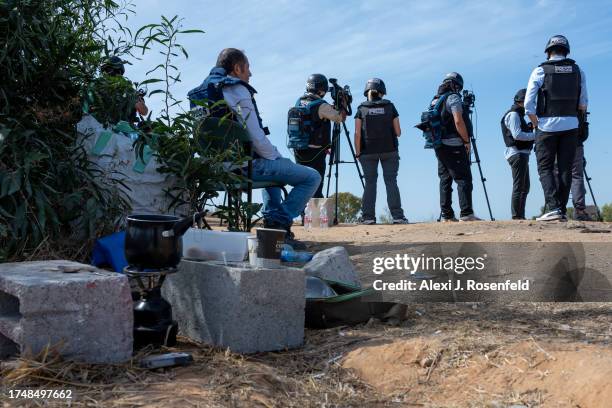 Fijan, and coffee stove is set up between some rocks near members of the press wait on an overlook to report rocket attacks from Gaza, or Israeli...