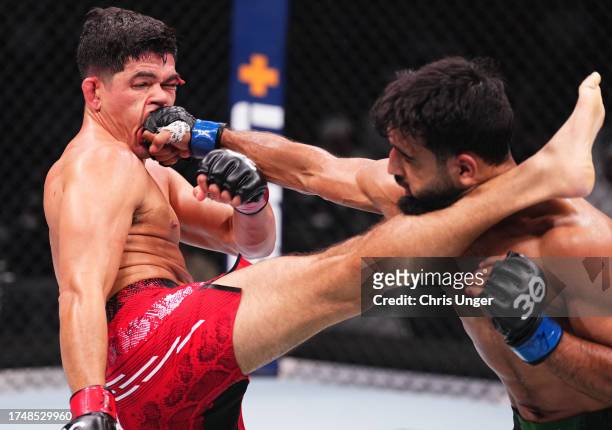 Mike Breeden and Anshul Jubli of India trade strikes in a lightweight fight during the UFC 294 event at Etihad Arena on October 21, 2023 in Abu...