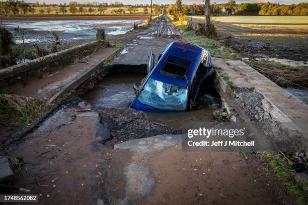 Car is seen in on bridge washed away following yesterdays torrential rain on October 21, 2023 in Dundee, Scotland. Rare Red weather warnings are in...