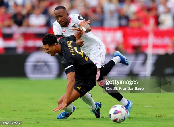 Jude Bellingham of Real Madrid is challenged by Dodi Lukebakio of Sevilla FC during the LaLiga EA Sports match between Sevilla FC and Real Madrid CF...