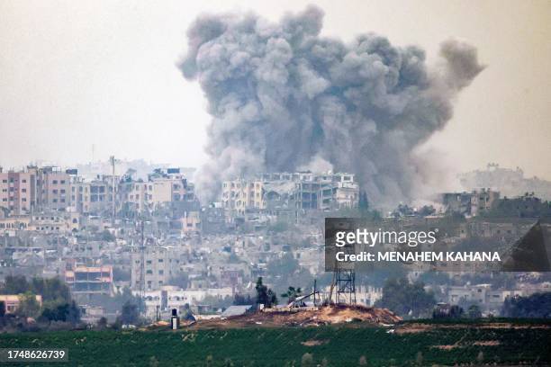This picture taken from a position along the border with the Gaza Strip near Israel's southern city of Sderot on October 27, 2023 shows a smoke plume...