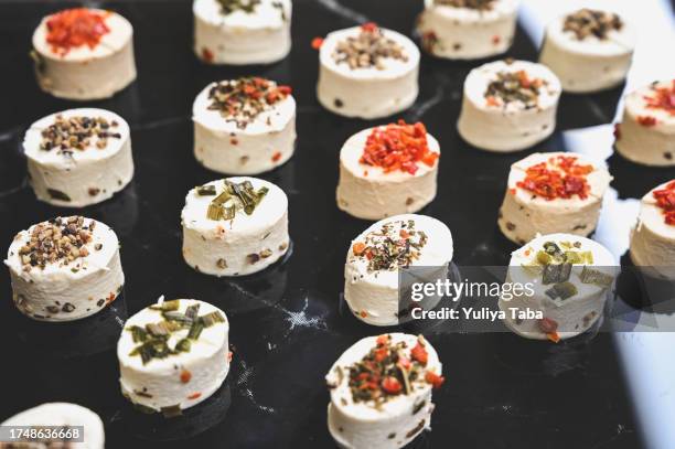 close up of a small cream cheeses with aromatic herbs. - antipasto stock pictures, royalty-free photos & images