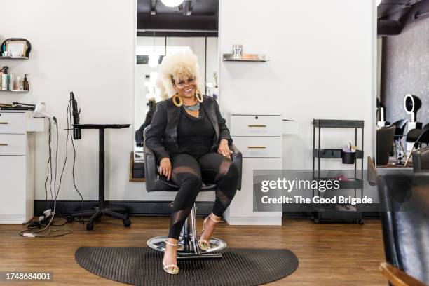 portrait of smiling woman sitting on chair at hair salon - 美容室　椅子 ストックフォトと画像