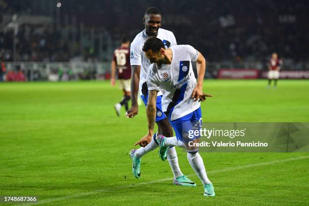 Hakan Calhanoglu of FC Internazionale celebrates with teammate Marcus Thuram after scoring the team's third goal from a penalty during the Serie A...