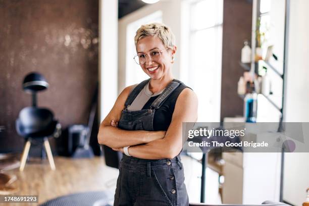 portrait of hairstylist standing with arms crossed at salon - frisör bildbanksfoton och bilder