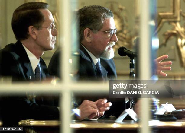 Brazilian Foreign Minister Celso Lafer sits next to his Argentinian counterpart Adalberto Rodriguez Giavariani, their image is reflected on the...
