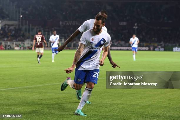 Hakan Calhanoglu of FC Internazionale celebrates with team mate Marcus Thuram after scoring to give the side a 3-0 lead during the Serie A TIM match...