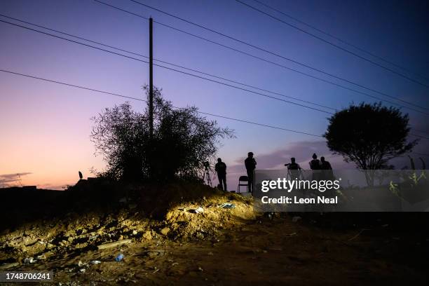 Members of the media look over towards Gaza City after sunset, as seen from the border area on October 21, 2023 near Sderot Israel. As Israel...