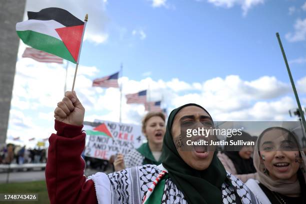 Pro-Palestinian protesters carry Palestinian flags as they march near the Washington Monument during a demonstration calling for a ceasefire in Gaza...