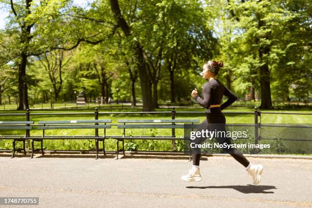 multiracial girl jogging in central park - walking city stock pictures, royalty-free photos & images
