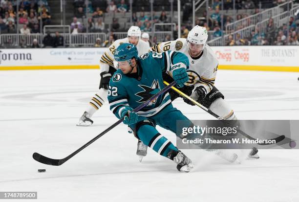 Kevin Labanc of the San Jose Sharks skating with the puck is checked to the ice by Pavel Zacha of the Boston Bruins during the second period at SAP...