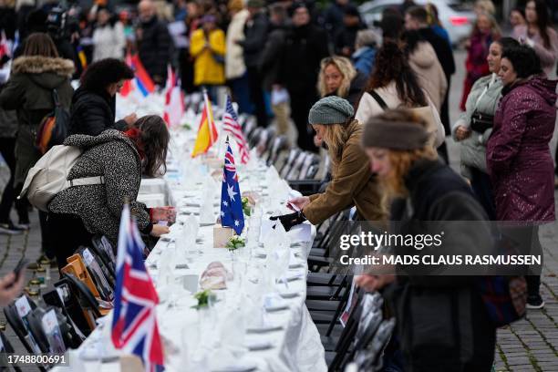 Activists decorate a Shabbat table for the over 220 hostages with a place for everyone of them, during an event organized by the Jewish Society, at...