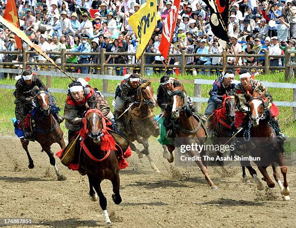 Horseback riders in full-body armor compete during the 'Soma Nomaoi Festival' on July 23, 2012 in Minamisoma, Fukushima, Japan. Some 350 riders...