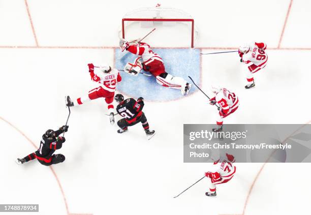 Vladimir Tarasenko of the Ottawa Senators shot is blocked by Moritz Seider of the Detroit Red Wings as Ville Husso dives to cover his net while his...