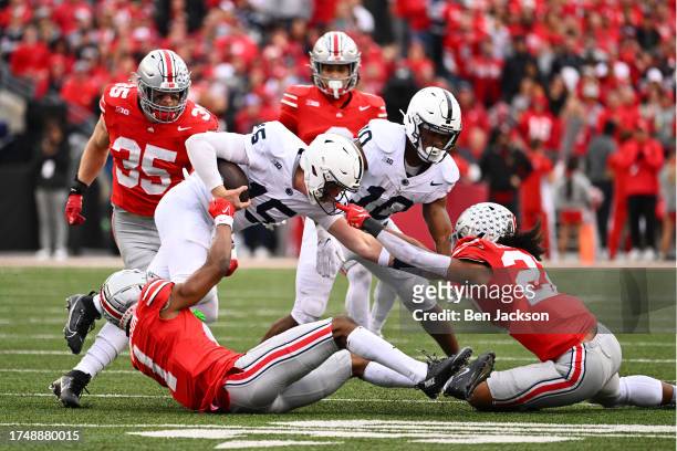 Quarterback Drew Allar of the Penn State Nittany Lions is pulled down by his facemask by Steele Chambers of the Ohio State Buckeyes during the fourth...
