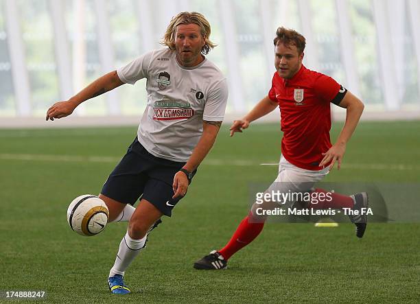 Robbie Savage of Team Grimshaw in action against Olly Murs of Team Murs during the BBC Radio 1 five-a-side football match between Team Grimshaw,...