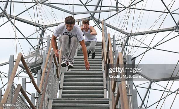 Pip Andersen professional freerunner and parkour expert is followed by Tim Shieff as they jump down the stairs to the viewing platform below the roof...