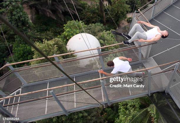 Pip Andersen professional freerunner and parkour expert runs beneath Tim Shieff as they jump down the stairs to the viewing platform below the roof...