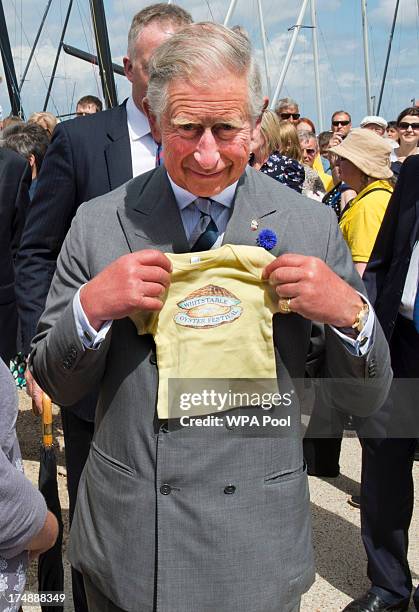 Prince Charles, Prince of Wales is seen with a present for his grandson Prince George of Cambridge during a visit to The Whitstable Oyster Festival...