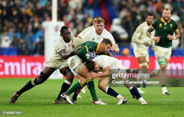 Willie Le Roux of South Africa is tackled by Owen Farrell and Maro Itoje of England during the Rugby World Cup France 2023 match between England and...