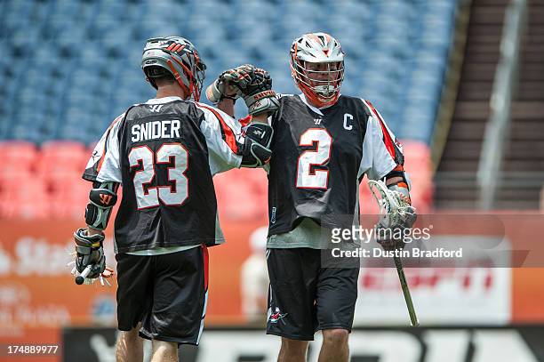 Drew Snider and Brendan Mundorf of the Denver Outlaws celebrate a goal against the Chesapeake Bayhawks during a Major League Lacrosse game at Sports...