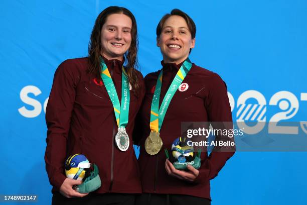 Silver medalist Sophie Angus of Canada and gold medalist Rachel Nicol of Canada pose in the podium of Women's 100m Breaststroke at Aquatics Center of...