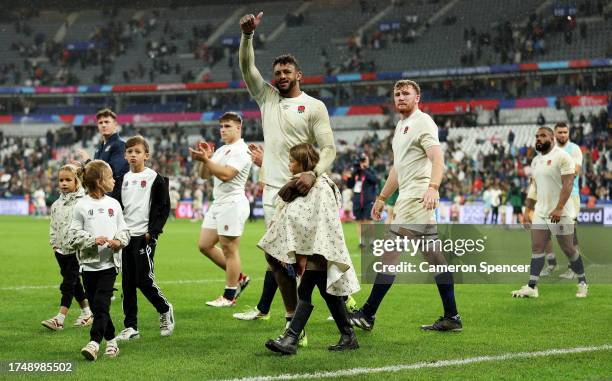 Courtney Lawes of England acknowledges the fans as he walks the pitch with his children following the team's defeat during the Rugby World Cup France...