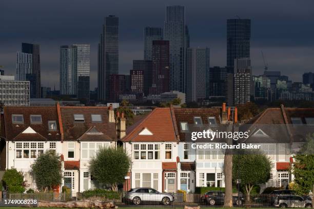 Suburban residential properties and distant city high-rises in Ruskin Park, a public green space in Lambeth, on 26th October 2023, in London, England.