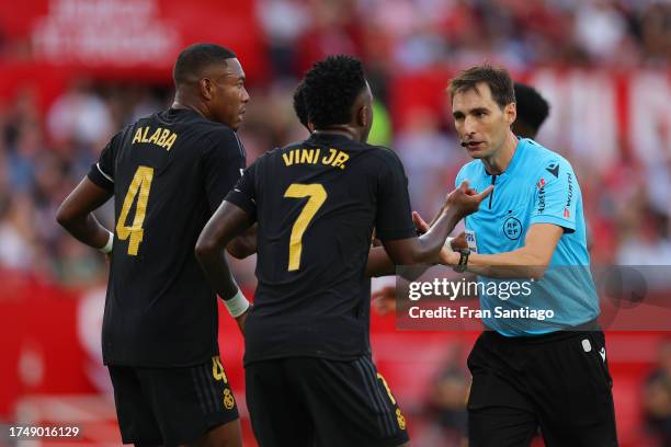 David Alaba and Vinicius Junior speak to the referee De Burgos Bengoechea during the LaLiga EA Sports match between Sevilla FC and Real Madrid CF at...