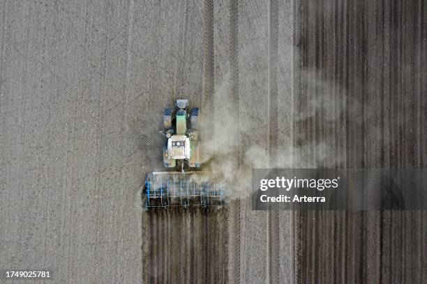 Tractor with seedbed cultivator, agricultural machine for stirring and aerating the soil and preparing a smooth, loose seedbed in a field in spring.