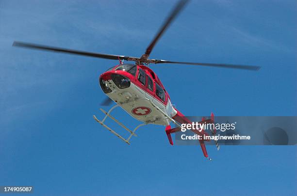 closeup of flying red helicopter in contrast with blue sky - traumahelikopter stockfoto's en -beelden