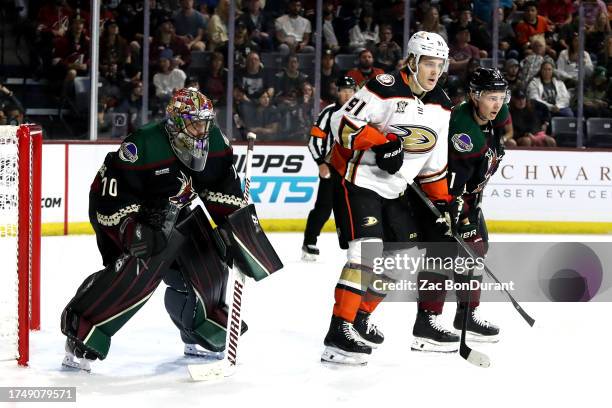 Leo Carlsson of the Anaheim Ducks fights for position in front of Karel Vejmelka of the Arizona Coyotes with Troy Stecher of the Arizona Coyotes...