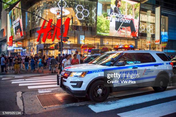 Police car in front H&M store at night,Times Square,New York City,United States of America. NYPD patrol car at Times Square. Manhattan