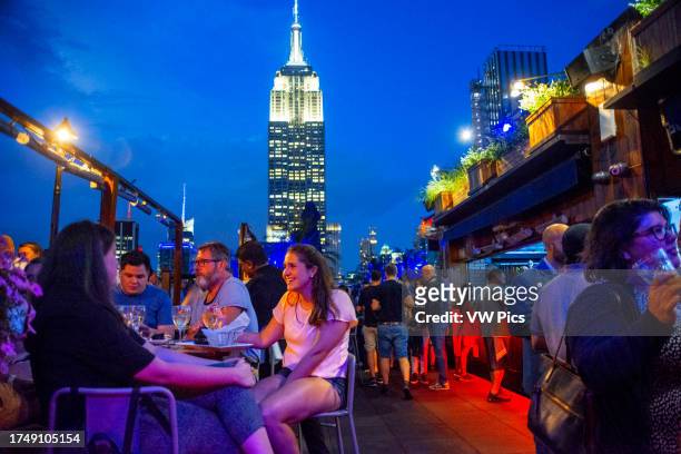 Roof top bar on Fifth Avenue,with views Empire State Building of Manhattan New York City,New York,United States. 230 Fifth" is a plush lounge located...