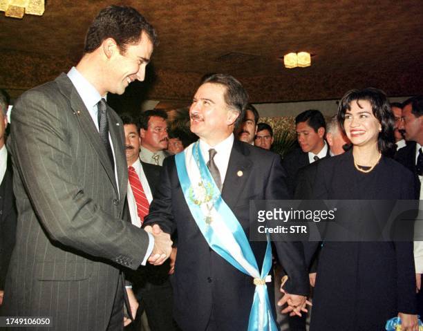 Spanish Crown Prince Felipe de Borbon shakes hands with newly sworn-in Guatemalan President Alfonso Portillo, who is accompanied by his wife Evelyn...
