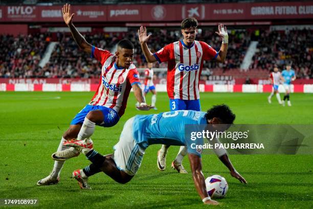 Celta Vigo's Peruvian midfielder Renato Tapia fights for the ball with Girona's Brazilian forward Savio Moreira and Girona's Spanish defender Miguel...