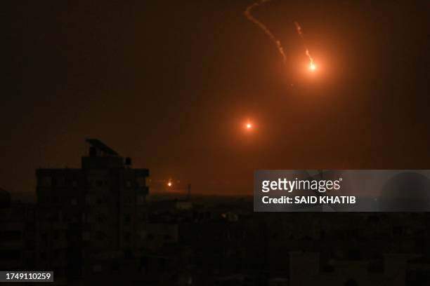 Flares fired by the Israeli army light up the sky east of Khan Yunis on the southern Gaza Strip on October 27, 2023 as battles between Israel and the...