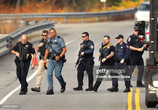 Lisbon, ME Heavily armed police walk near near the boat launch in the Androscoggin River on Rt 196 where suspect Robert Card abandoned his car...