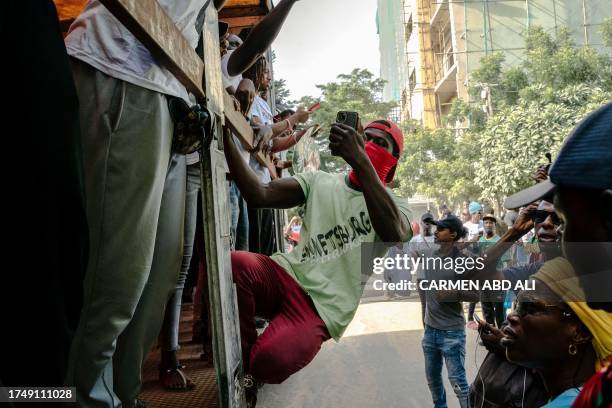 Demonstrator uses his smartphone during a rally called by Senegal's new opposition coalition "F24 Movement of Vital Forces" to demand the release of...