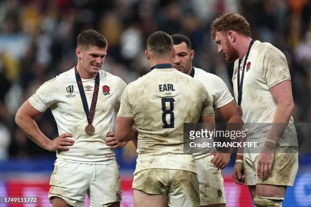 England's fly-half Owen Farrell, England's prop Ellis Genge and England's lock Ollie Chessum reacts with their medals after winning the France 2023...