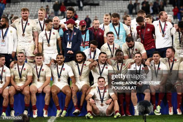 England's players pose during the medal ceremony after winning the France 2023 Rugby World Cup third-place match between Argentina and England at the...