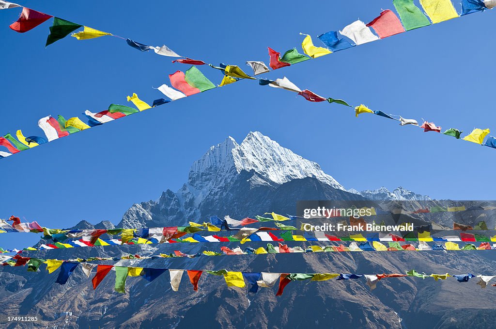 Buddhist prayer flags in front of Kangtega Mountain above...