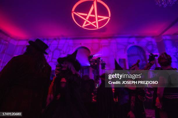 Pentagram symbol glows on the ceiling as costumed revelers enjoy the Witches' Ball ahead of Halloween in Salem, Massachusetts, on October 27, 2023.